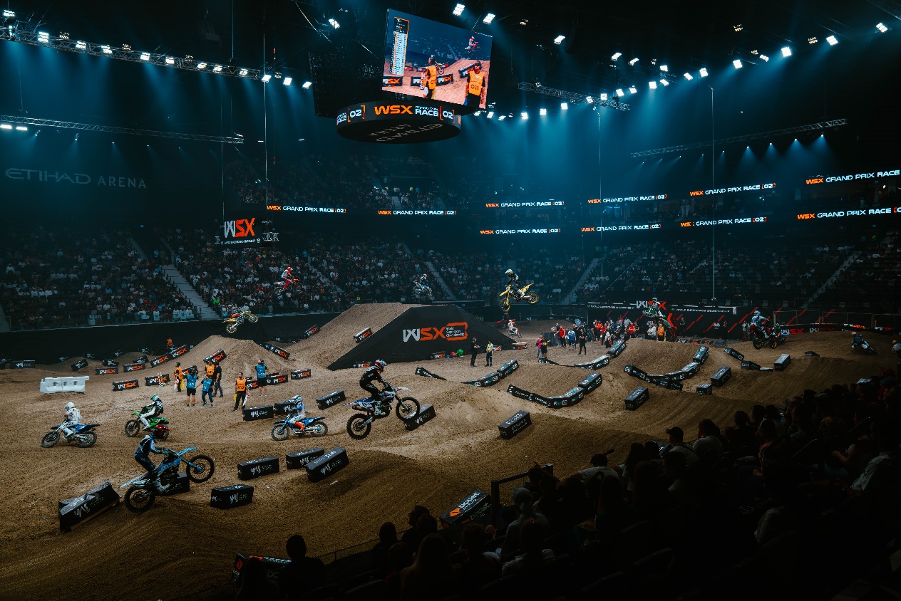 A dirt bike arena with people in the backgroundDescription automatically generated